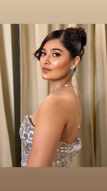Woman in a silver corset gown, back view